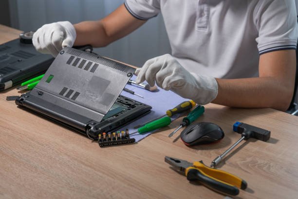 Técnico con guantes instalando componentes en una notebook